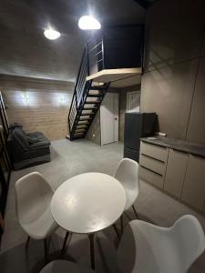 a white table and chairs in a kitchen with a staircase at Green Village in Balqash