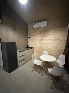 a kitchen with a table and chairs and a refrigerator at Green Village in Balqash