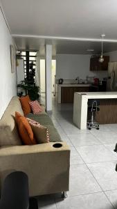 a living room with a couch and a kitchen at El Encanto Alajuela in Alajuela