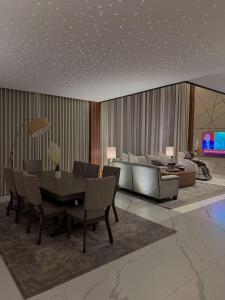 a living room with a dining table and a couch at نارس البخاري in Buraydah