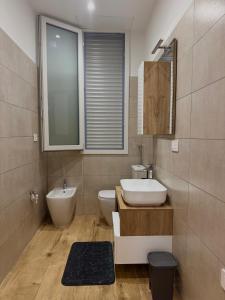 a bathroom with a sink and a toilet and a mirror at FraDom House in Montesilvano