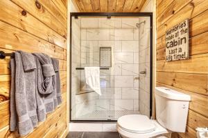 a bathroom with a toilet and a glass shower at Mountain View Hot Tub Cabin w Pool Table Romantic in Sevierville
