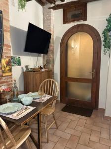 a dining room with a table with chairs and a television at Rifugio della Contea - Centro storico Perugia in Perugia