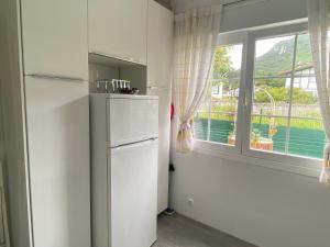 a white refrigerator in a kitchen with a window at La Choza in Oriñón