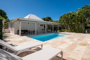 a swimming pool in the backyard of a house at Sweet Cane Tiny House & Pool in Saint-François