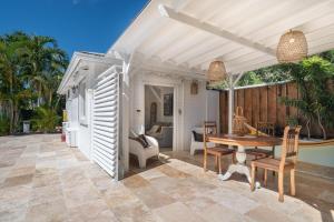 a patio with a wooden table and chairs at Sweet Cane Tiny House & Pool in Saint-François