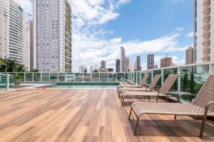 a rooftop deck with chairs and a city skyline at Point Convenience by Marzani Host in Goiânia