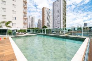 a swimming pool on top of a building with tall buildings at Point Convenience by Marzani Host in Goiânia