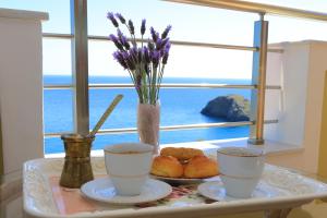 a table with two cups and a plate of food on it at Villa Thea, By IdealStay Experience in Kaloi Limenes