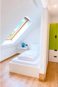 a white bedroom with a bed and a window at Mikes Fewo in Hohegeiß
