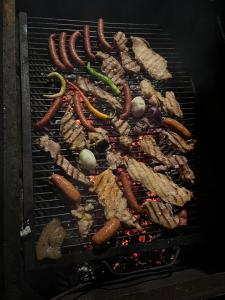 a bunch of meat and vegetables cooking on a grill at Casa Blanca in Caransebeş