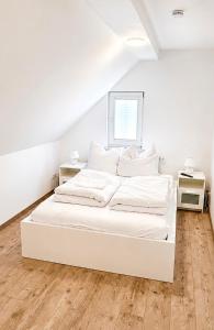 a white bed in a white room with a window at Mikes Fewo in Hohegeiß