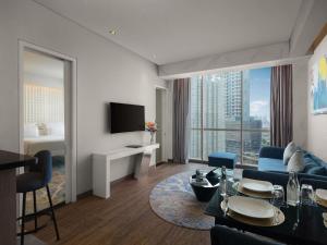 a living room with a couch and a tv at Pullman Jakarta Central Park in Jakarta