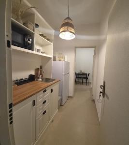 a kitchen with a white refrigerator and a table at פינה בשדה in Sede Naẖum +17 photos