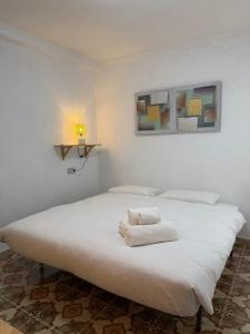 a white bed with towels on it in a room at Big vacation apartment BI in Guardamar del Segura