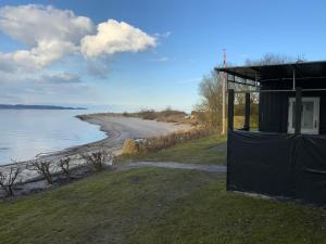 a building next to a beach with the ocean at Loff Holiday Houses in Aabenraa