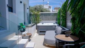 a small balcony with a hot tub and tables at Sentio Thassos Suites in Limenas