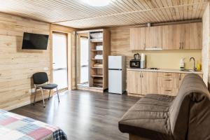 a room with a bed and a kitchen with a refrigerator at GreenHotel in Chornomorsk