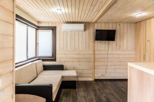 a living room with a couch and a tv at GreenHotel in Chornomorsk