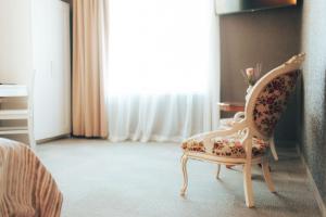 a bedroom with a chair and a window at Usmas muiža in Usma