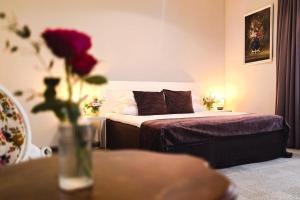 a bedroom with a bed and a vase with a flower at Usmas muiža in Usma