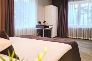 a hotel room with a bed and a sink at Usmas muiža in Usma