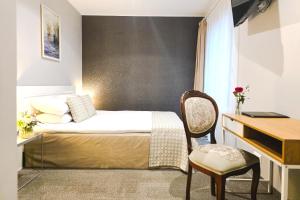 a bedroom with a bed and a desk and a chair at Usmas muiža in Usma