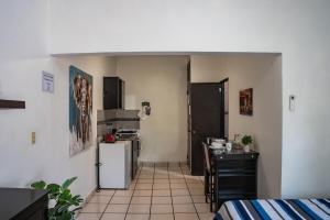 a kitchen with a refrigerator and a table in a room at Estudio #3 a 10 min del malecon in La Paz