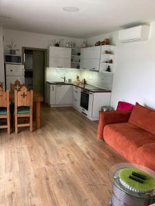 a living room with a red couch and a kitchen at Budha house in Lošonec