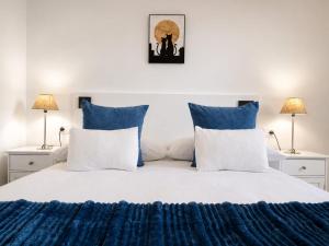 a bedroom with a bed with blue and white pillows at Delta in Monforte de Lemos