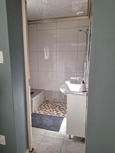 a bathroom with a shower and a sink and a tub at MERK Guest House in Piet Retief +14 photos