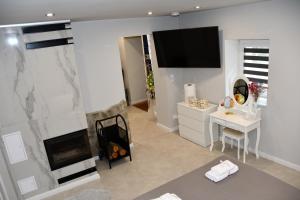 a living room with a fireplace and a tv on the wall at Lemon & Jacuzzi in Boguszów-Gorce