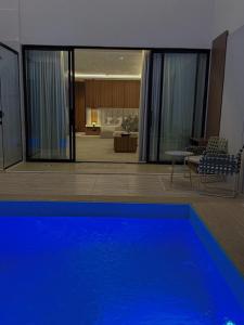 a house with a blue swimming pool in a living room at نارس البخاري in Buraydah