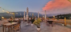 a restaurant with tables and umbrellas on a balcony at Guest House Juald in Gjirokastër