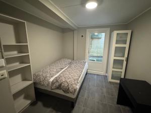 a small bedroom with a bed and a window at Bergen City hostel Rooms in Bergen