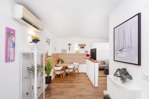 a living room and dining room with a dining table at Apartments Joy in Cavtat