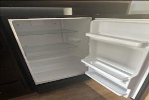 an empty refrigerator with its door open in a kitchen at Relax Inn Hotel in Birmingham