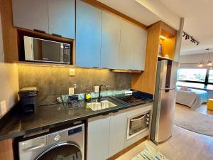 a kitchen with a sink and a washer and dryer at Linked 1001 - Aconchegante e dentro do Shopping in Porto Alegre