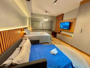 a hotel room with a bed and a tv at Linked 1001 - Aconchegante e dentro do Shopping in Porto Alegre +25 photos