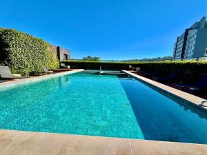 a swimming pool with blue water in a building at Linked 1001 - Aconchegante e dentro do Shopping in Porto Alegre