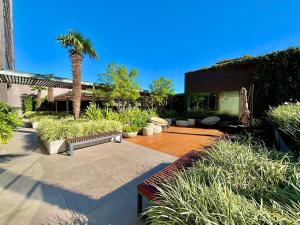 a courtyard with benches and a palm tree and a building at Linked 1001 - Aconchegante e dentro do Shopping in Porto Alegre