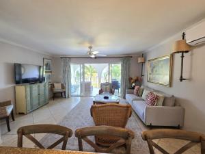 a living room with a couch and a tv at 117 Sapphire Beach Condo in Christ Church