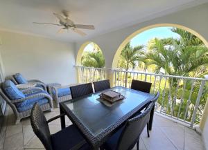a dining room with a table and chairs on a balcony at 117 Sapphire Beach Condo in Christ Church