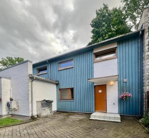 a blue and white building with a orange door at Villa Meri Apartments in Pärnu