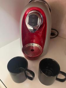 a red toaster sitting on a counter with three cups at Casa do Bosque in Sao Jose do Rio Preto