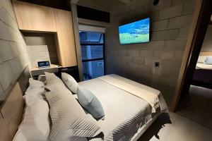 a bedroom with a bed and a tv on a wall at Our Home Granada in Cali