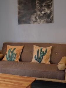 a couch with two pillows and a picture of a gorilla at Margarita in Oaxaca City +2 photos