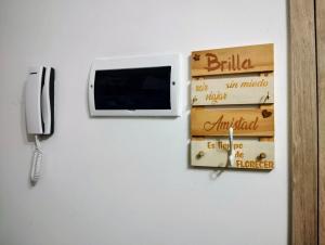 a wall with a tv and a phone on a wall at Diseñado para vos, a pasos de Bv Oroño con cochera opcional in Rosario