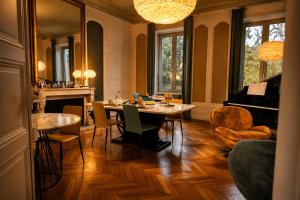 a dining room with a table and a piano at La Parenthèse Fléchoise, Chambre Raphaël in La Flèche
