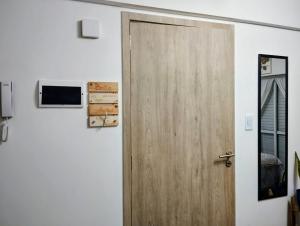 a wooden door in a room with a television at Diseñado para vos, a pasos de Bv Oroño con cochera opcional in Rosario
